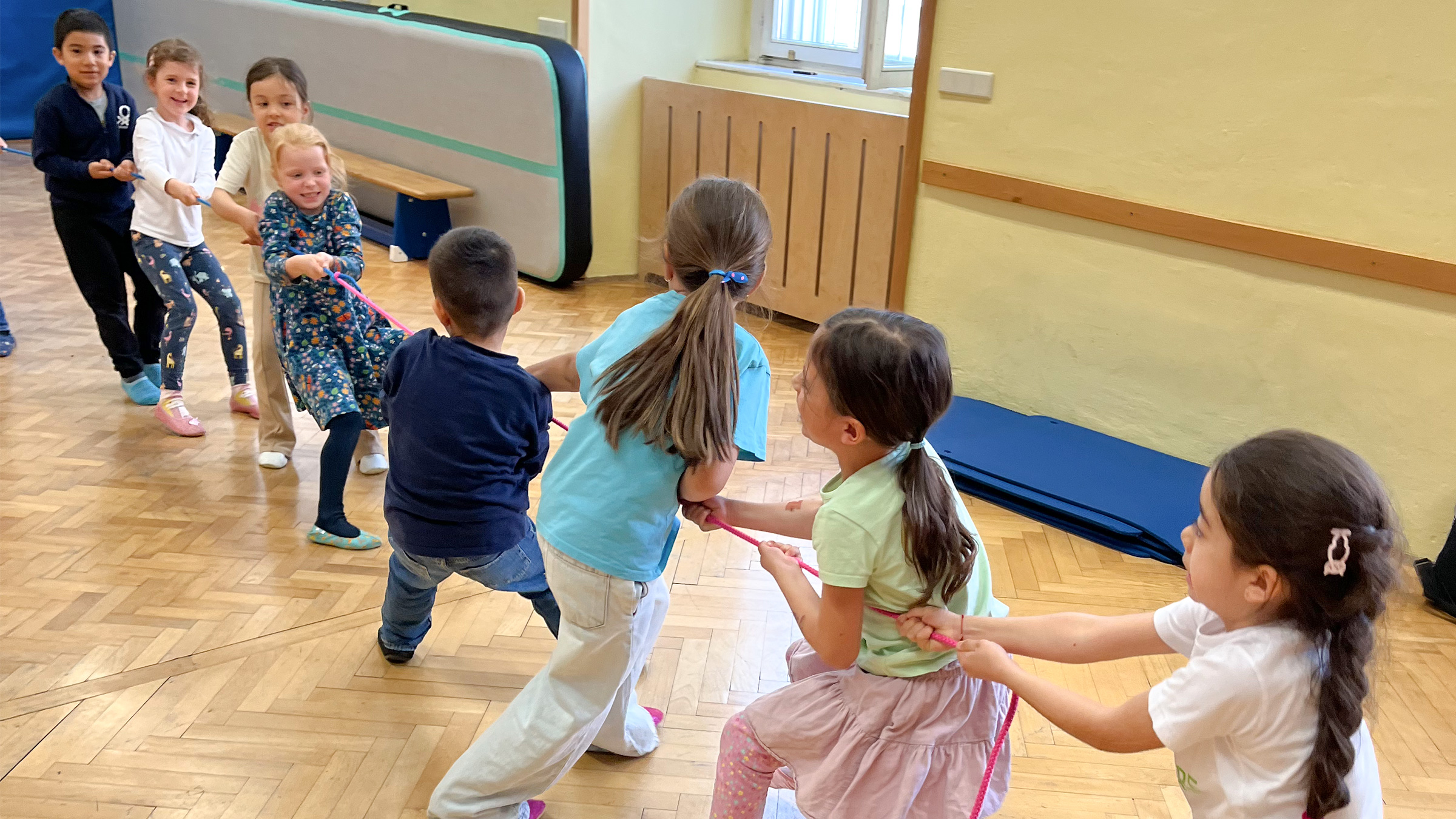 Gruppe von Vorschulkindern, die um die Wette Seil ziehen.