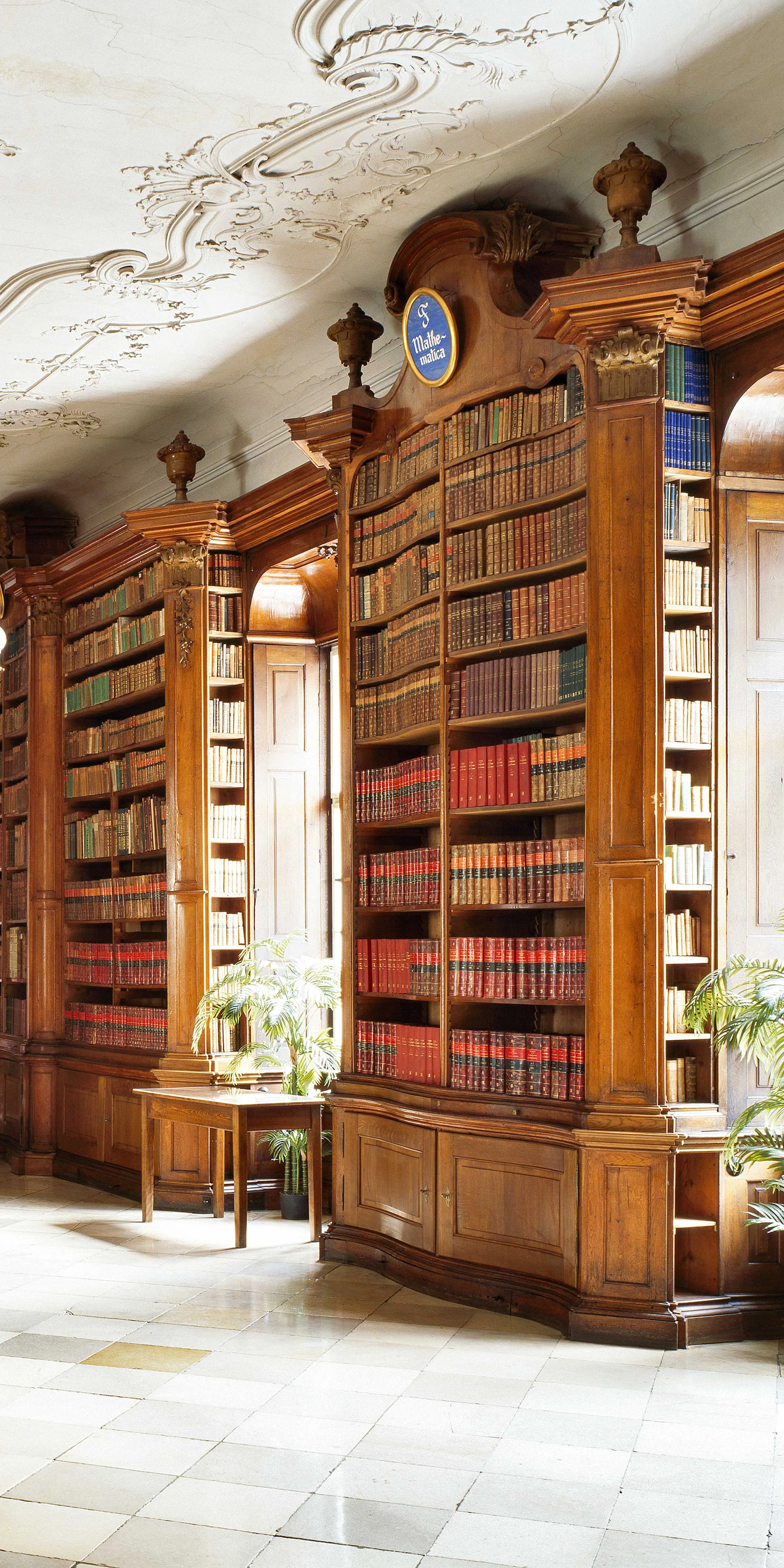 Ansicht einer historischen Bibliothek mit Stuckdecke und Marmorsteinboden