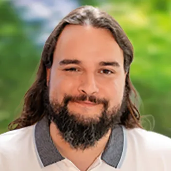 Portraitfoto eines Mannes mit dunklen langen Haaren und Vollbart
