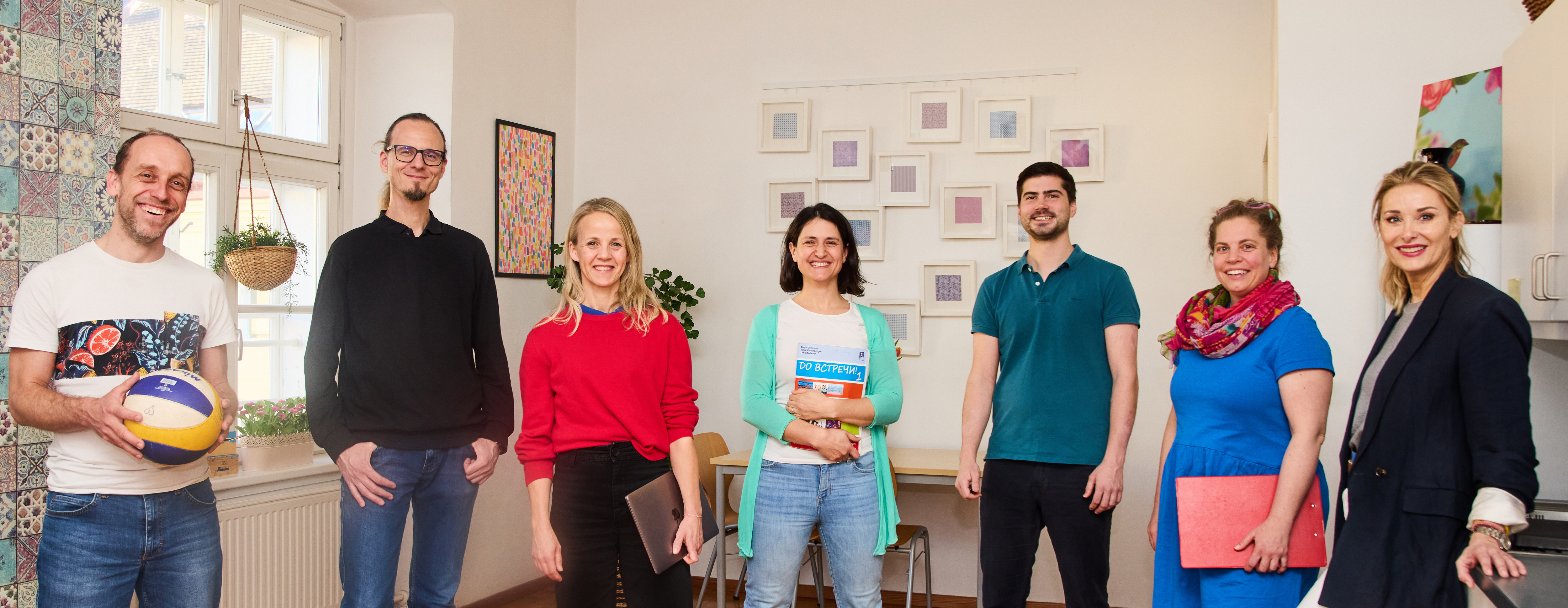 Gruppe von erwachsenen Personen in die Kamera lachend in einem Wohnzimmer stehend