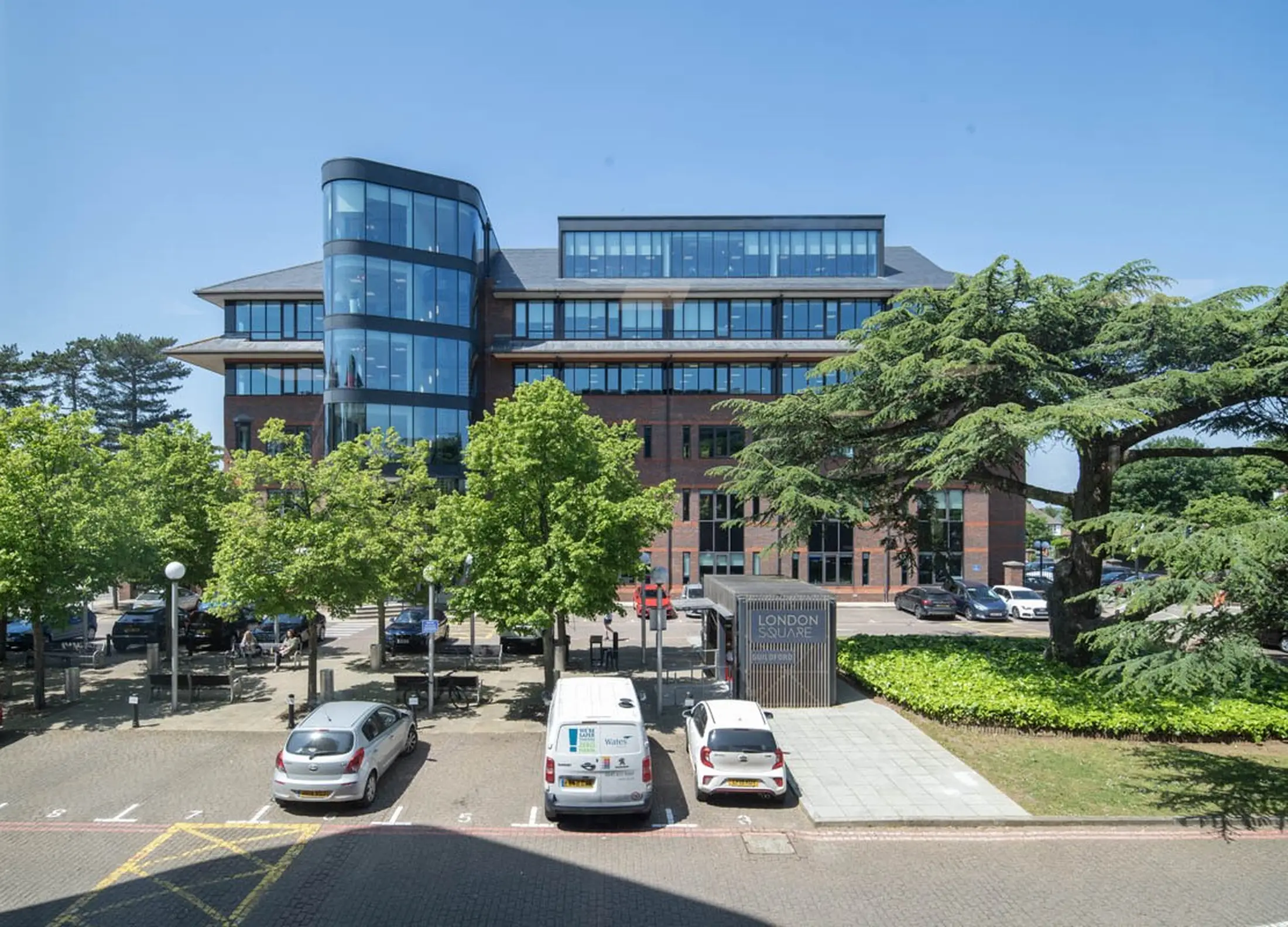 Modern office building with parked cars and trees