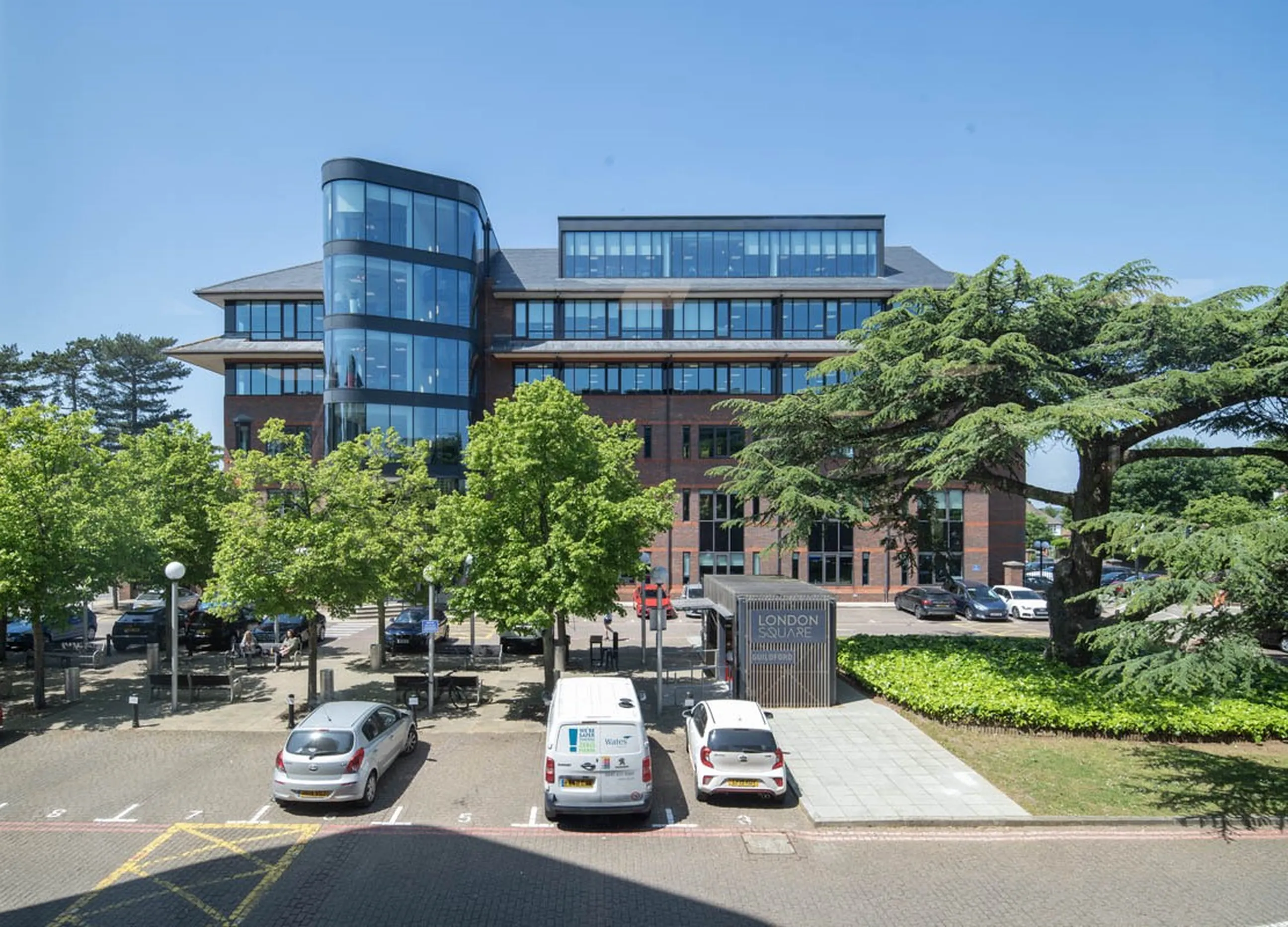 Modern office building with parked cars and trees