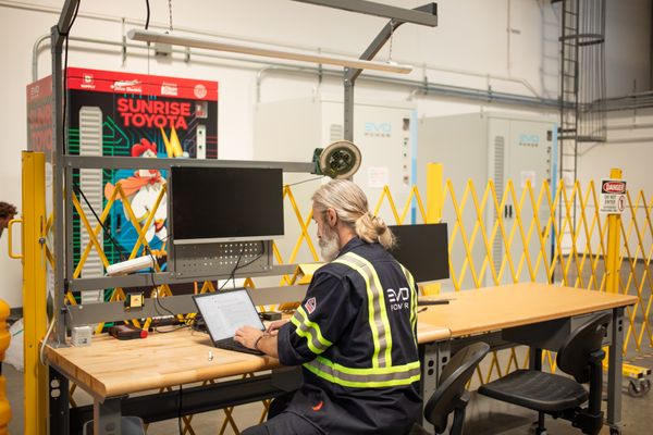Battery storage system being integrated to its EMS by a engineer sitting at a computer