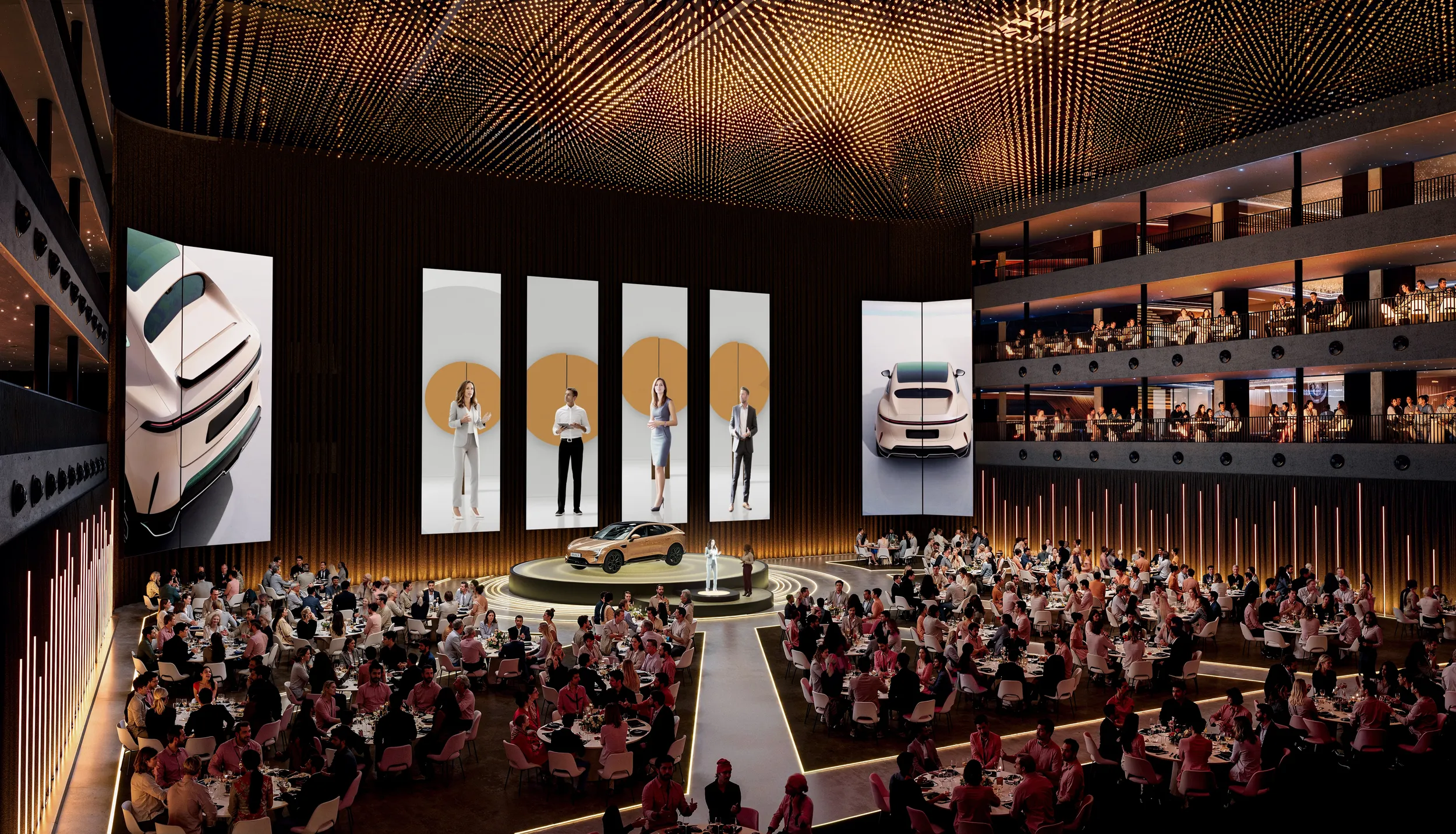 Large event hall with guests seated at round tables around a central stage where a car is being presented, surrounded by tall digital screens and multiple balcony levels with spectators.