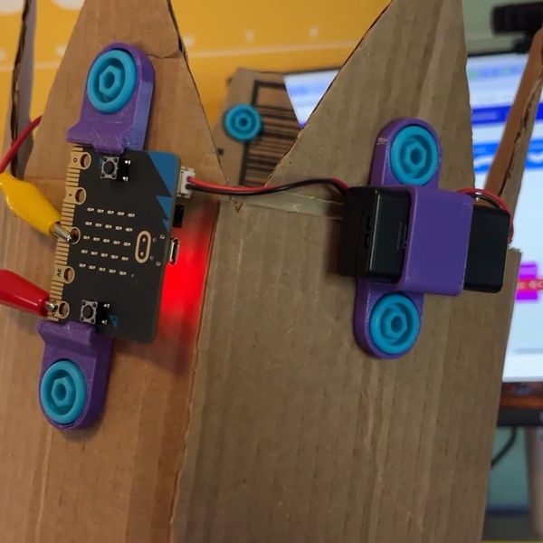 Cardboard crown with 3D printed micro:bit attachments held in place by Makedo Scrus.