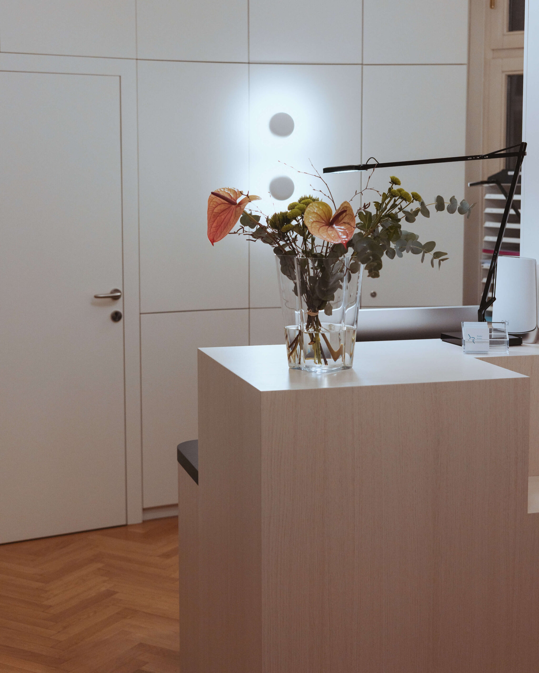 Rezeption in der Ordination RiederKager, stilvoll dekoriert mit Blumenarrangement.