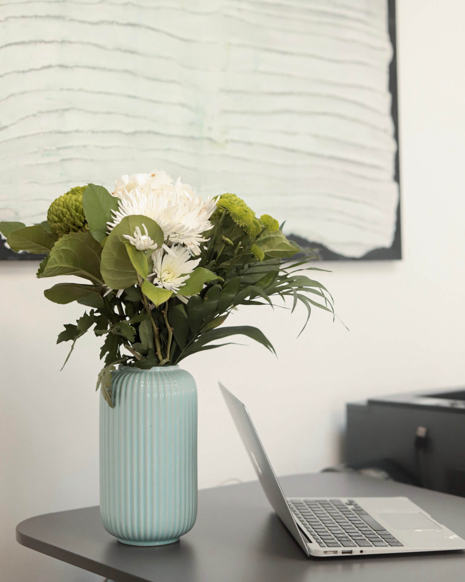 Vase mit frischen Blumen auf einem Schreibtisch in der Ordination RiederKager in Krems.