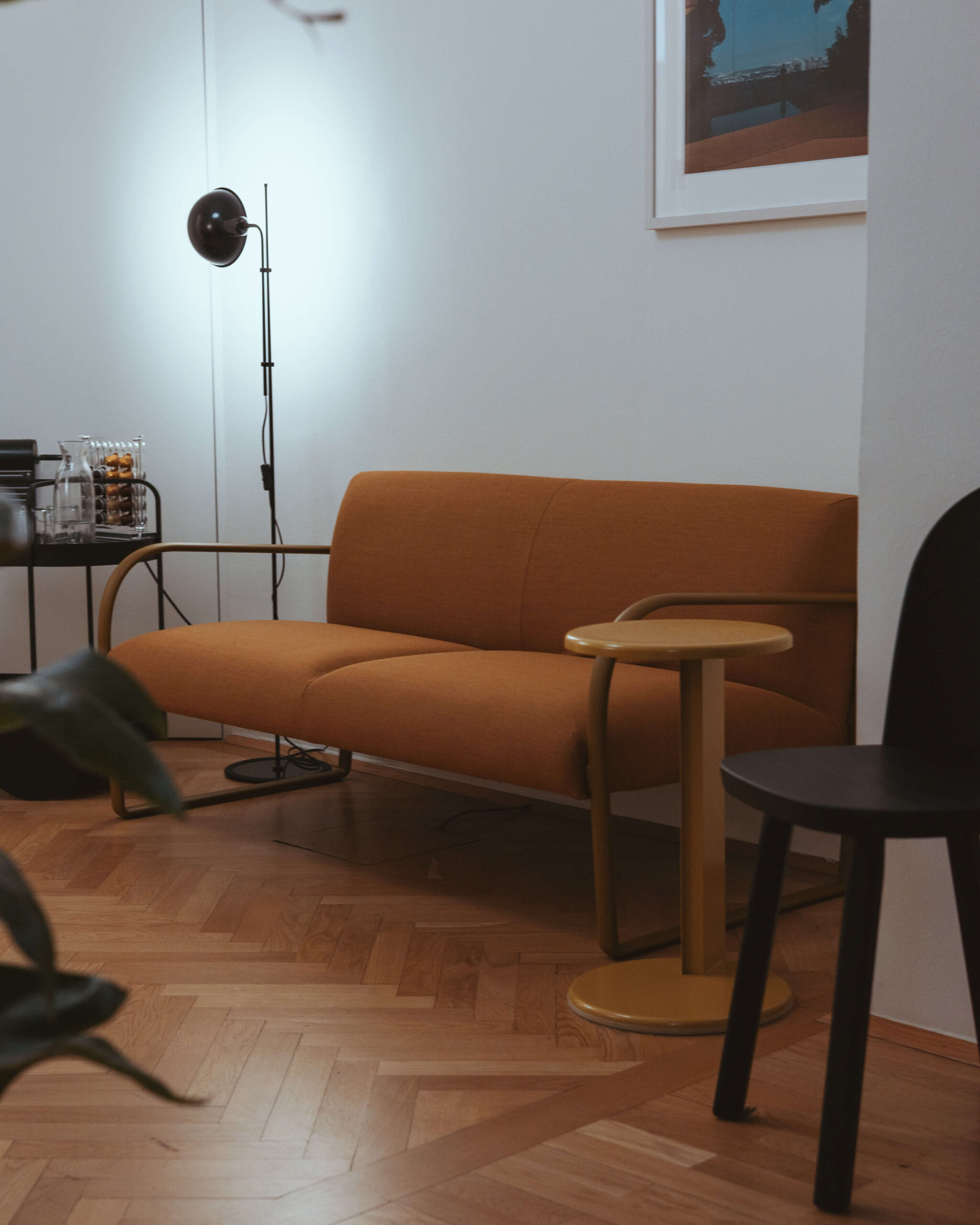 Gemütlicher Wartebereich mit einer braunen Couch und stilvollem Dekor in der Ordination RiederKager.