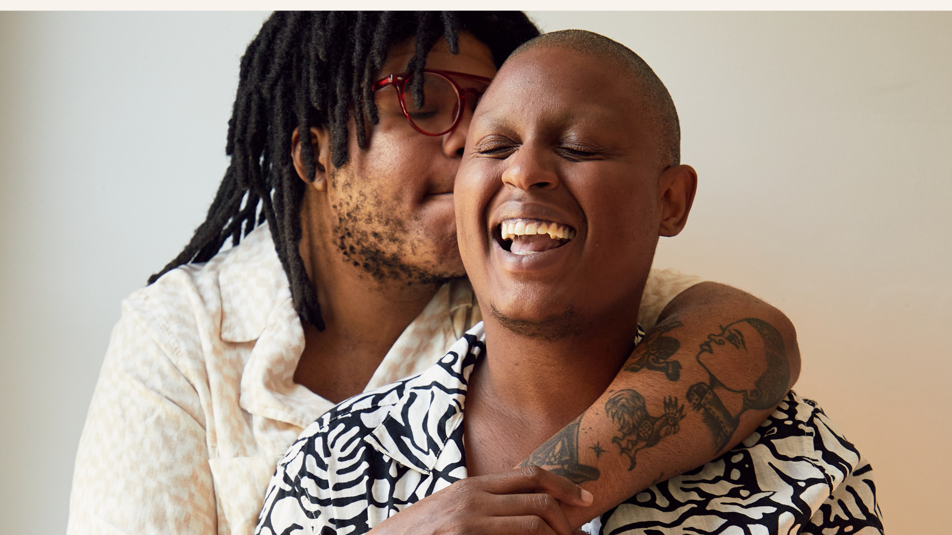 LGBTQ+ couple smiling and embracing