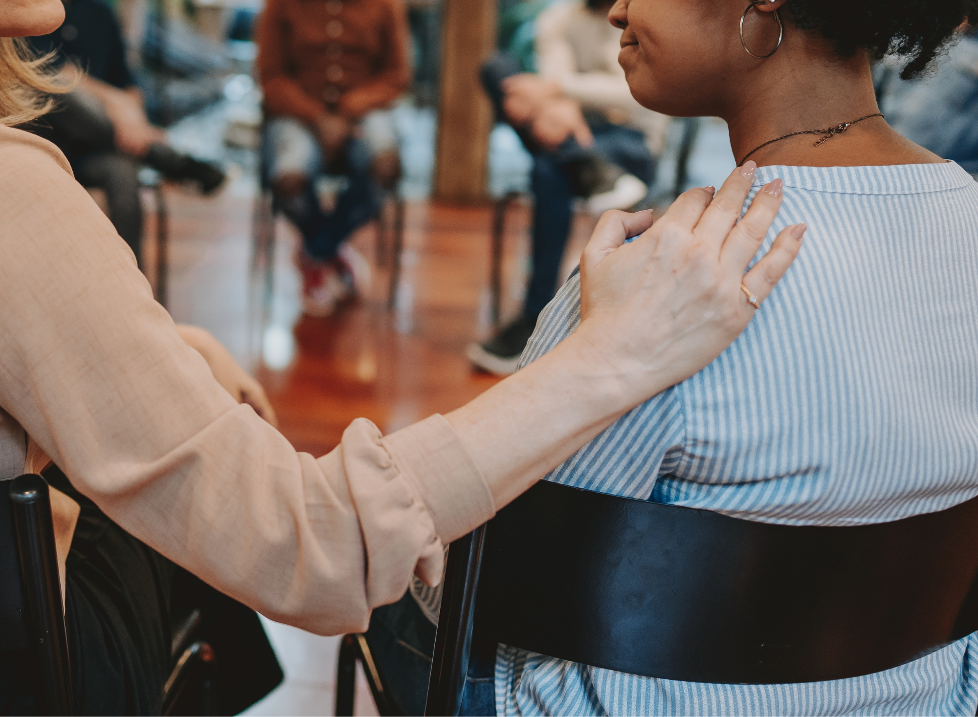 womans hand on other woman in support at fertility support group