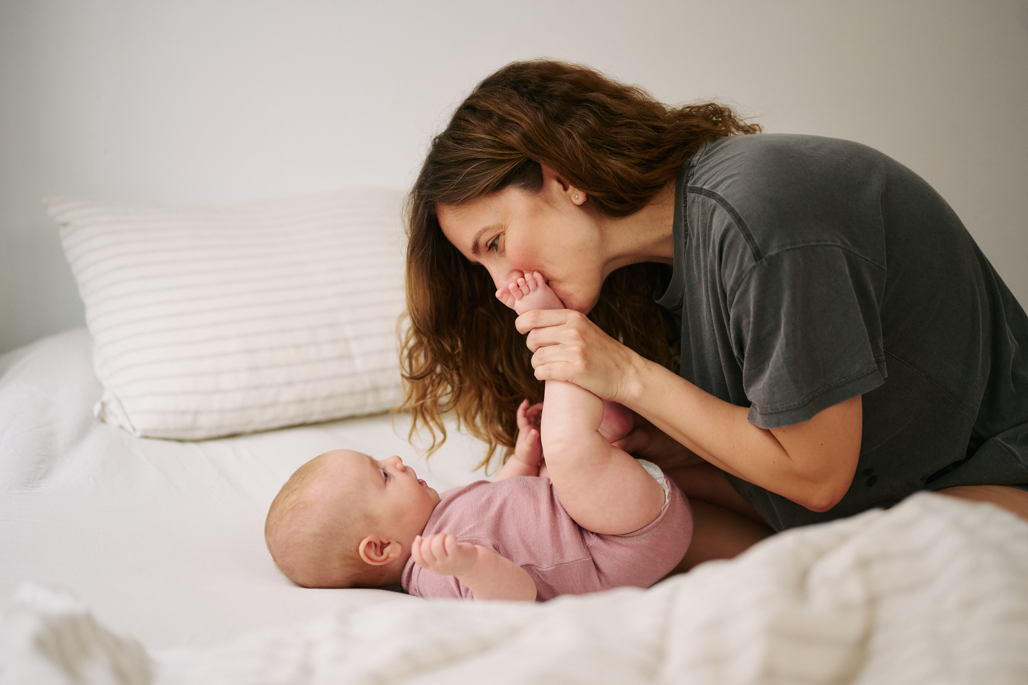 Mother kissing newborn baby's feet