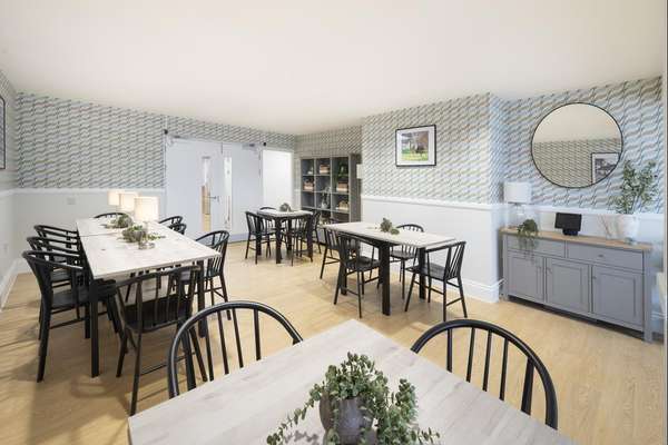 Bright dining room with wooden tables, black chairs, and geometric wallpaper. Decor includes a round mirror, plants, and framed art.