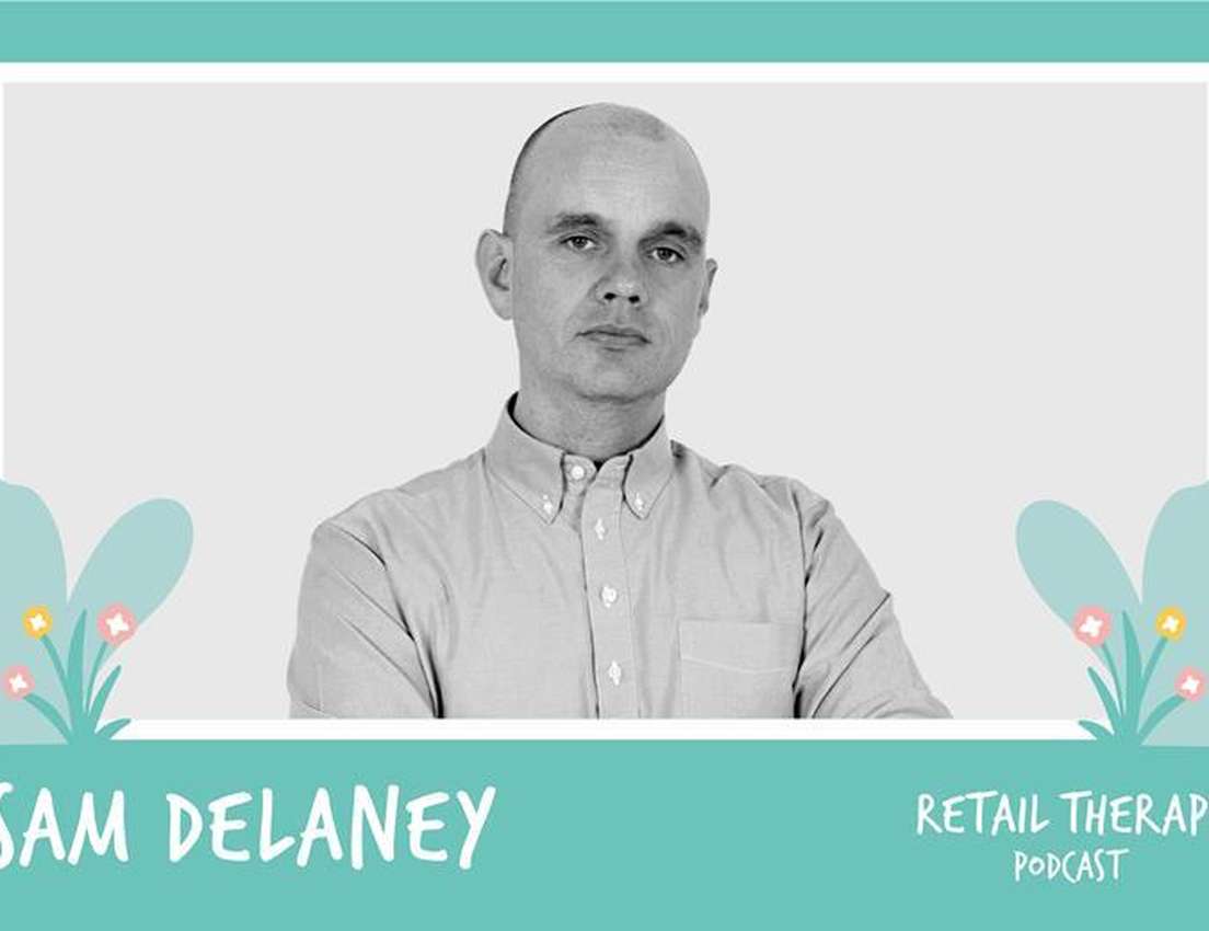 Grayscale portrait of a bald man in a button-down shirt, framed on a teal background with text 'SAM DELANEY' and 'RETAIL THER