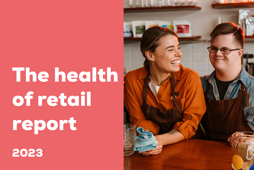The health of retail report 2023 title next to a smiling female barista and a male colleague with Down syndrome at a counter.