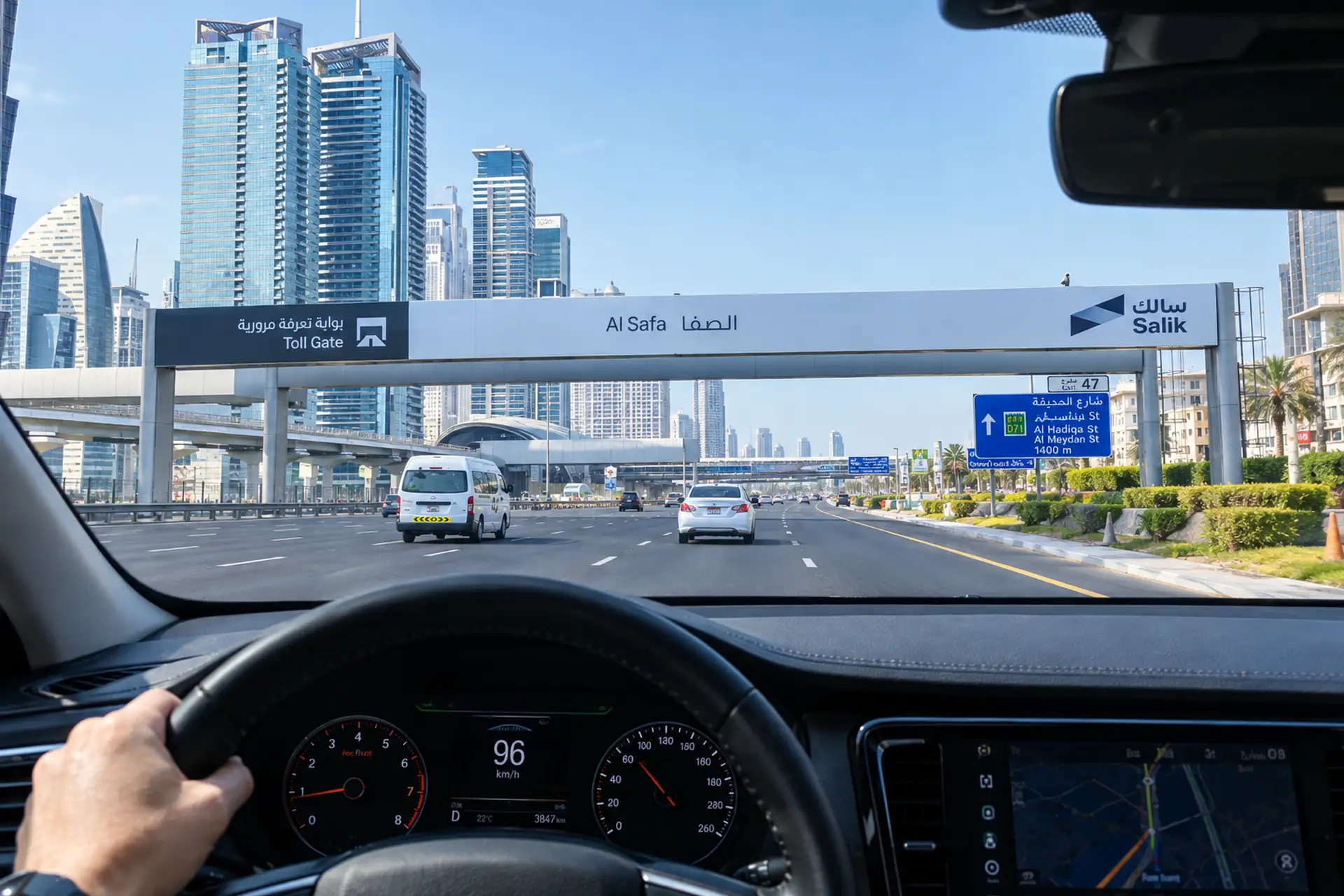 View from inside a car driving on a highway towards Al Safa Toll Gate, with skyscrapers and road signs visible in the distance.