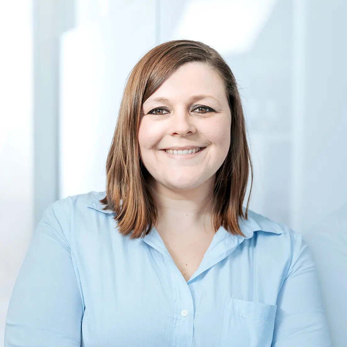 Smiling woman in a light blue shirt.