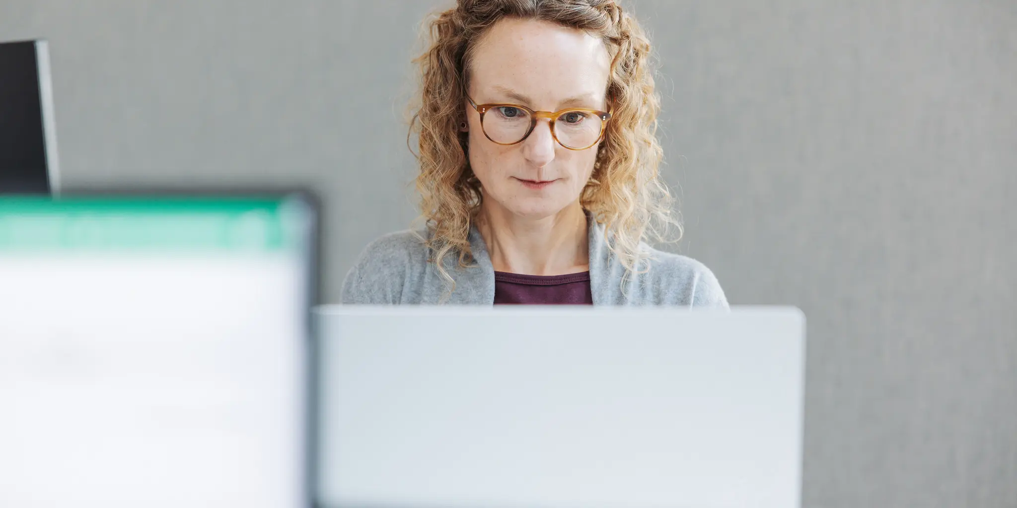 Eine Pressereferentin liest morgens den täglichen Medienspiegel auf ihrem Laptop