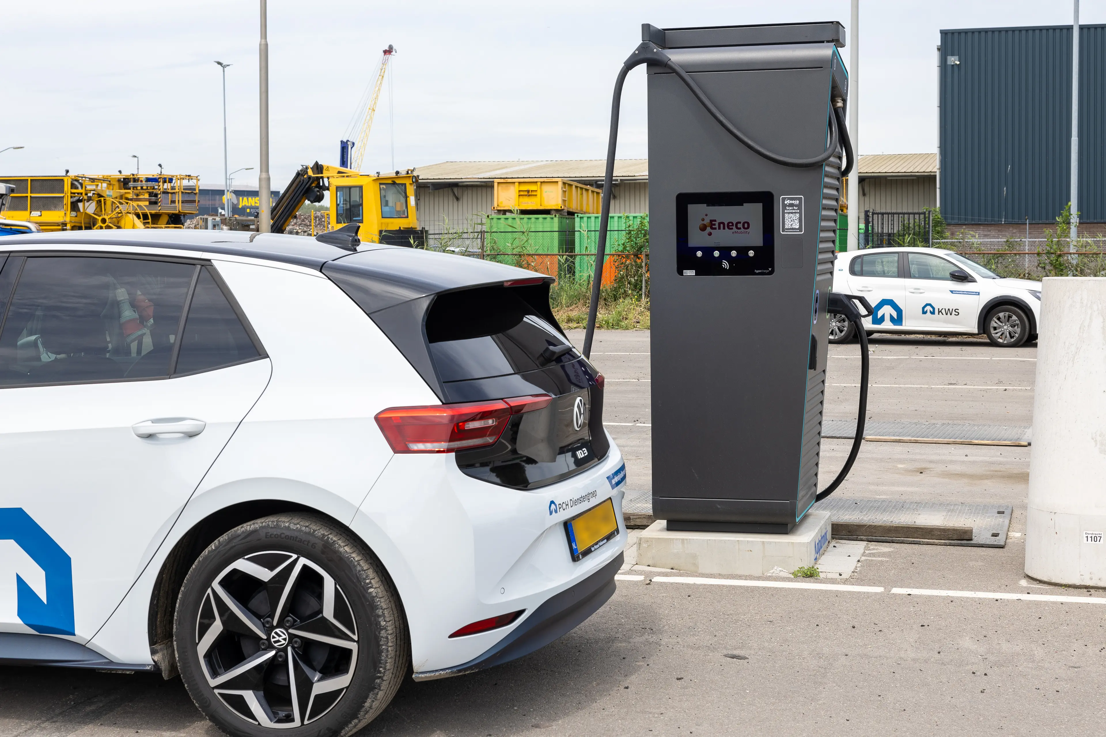 Elektrische auto laadt aan een Eneco snellader op een bedrijfsterrein