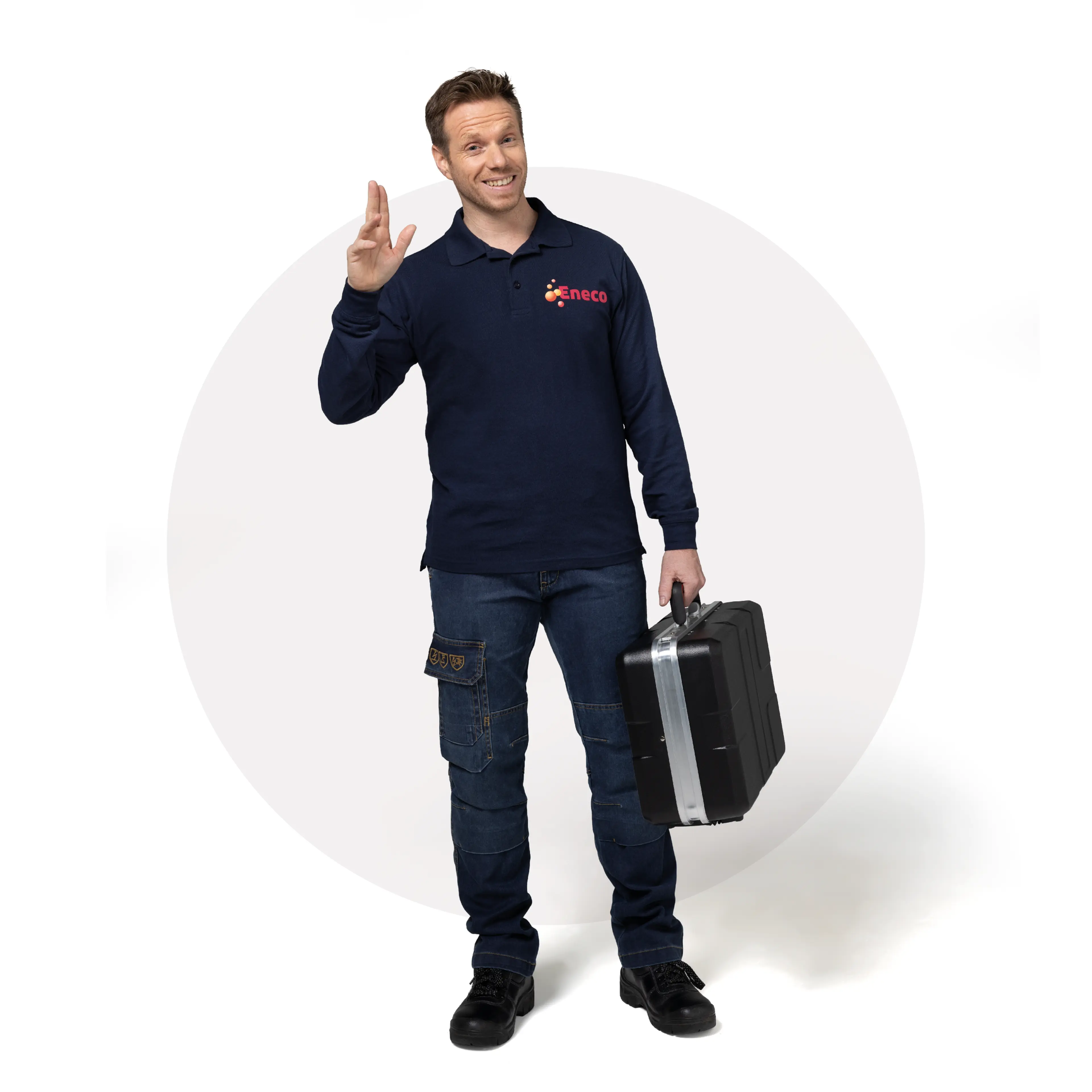 A man in a navy shirt waves while holding a toolbox. / Een man in een marineblauwe shirt wuift met een gereedschapskoffer.