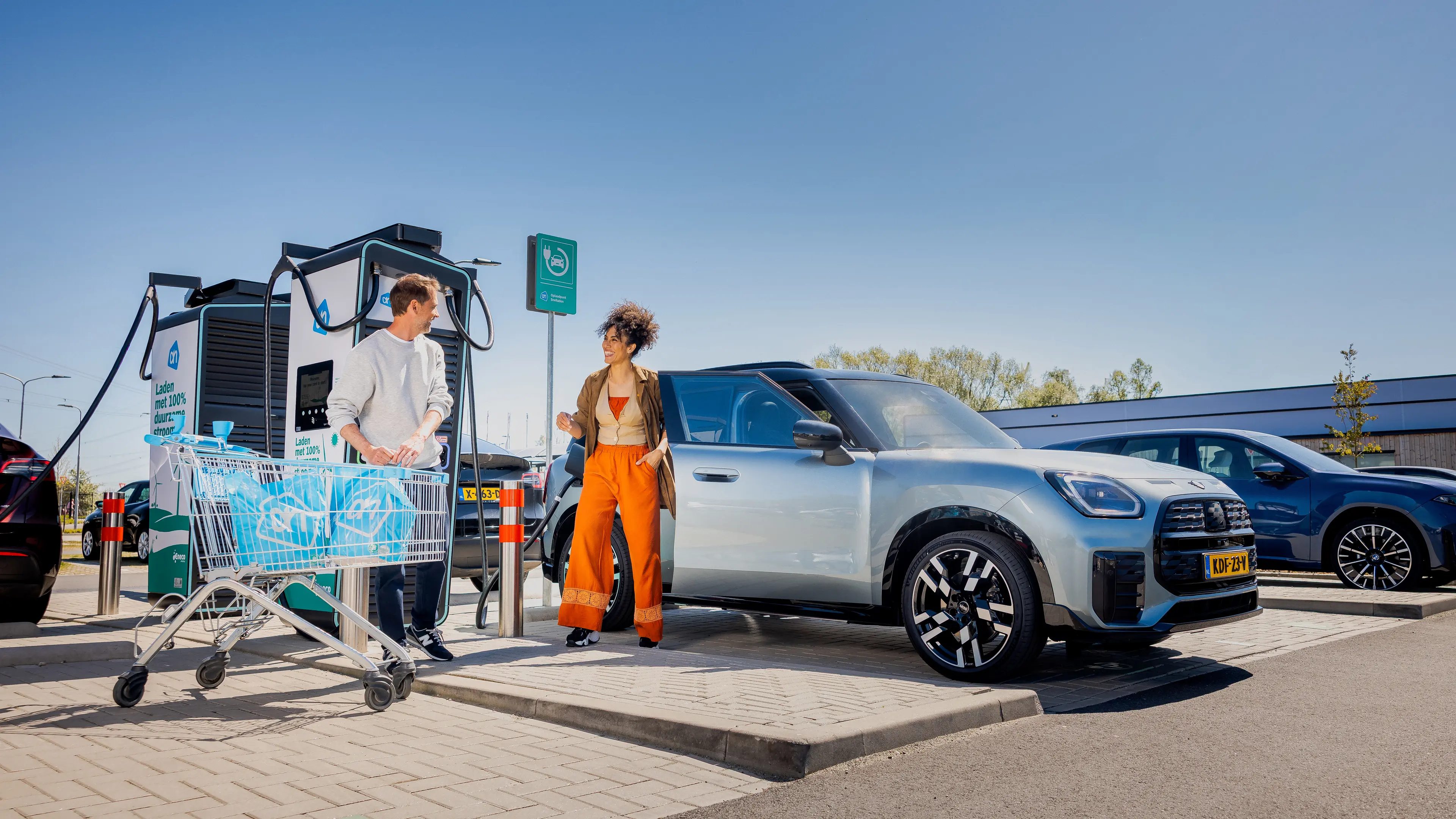 Iemand met een winkelwagen bij een snellader