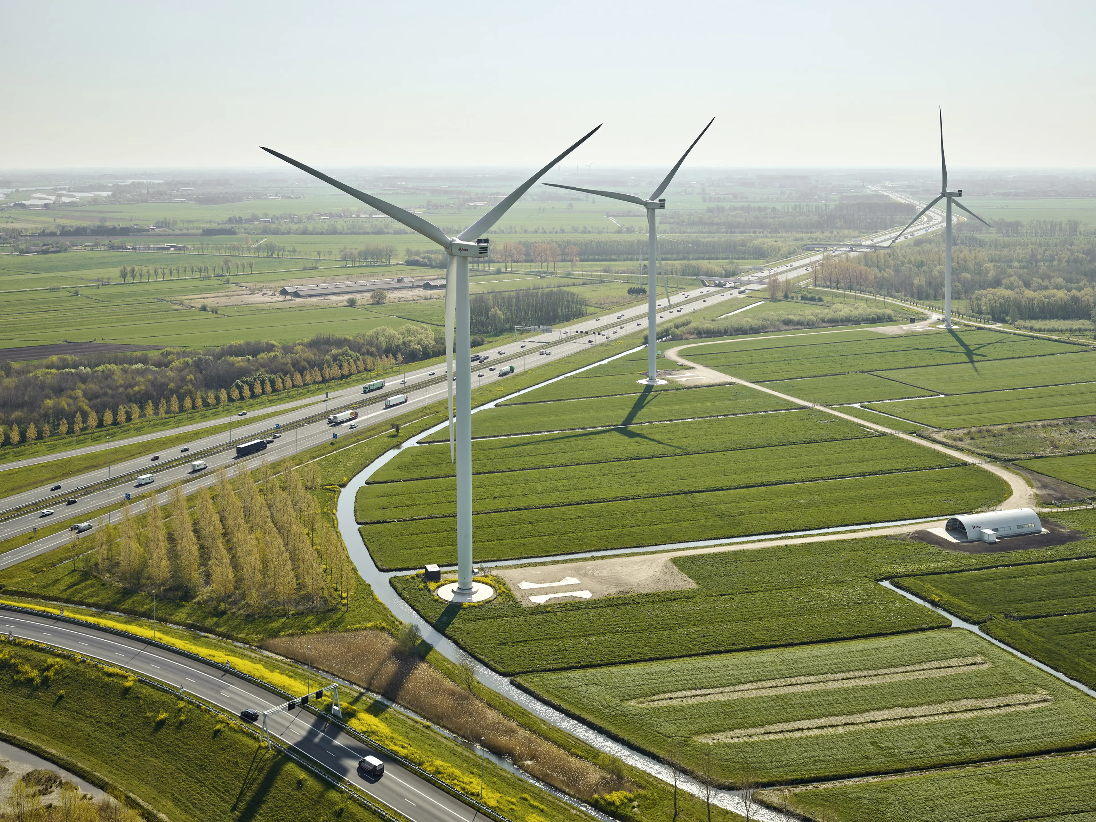 Windmolens in een polder langs een snelweg