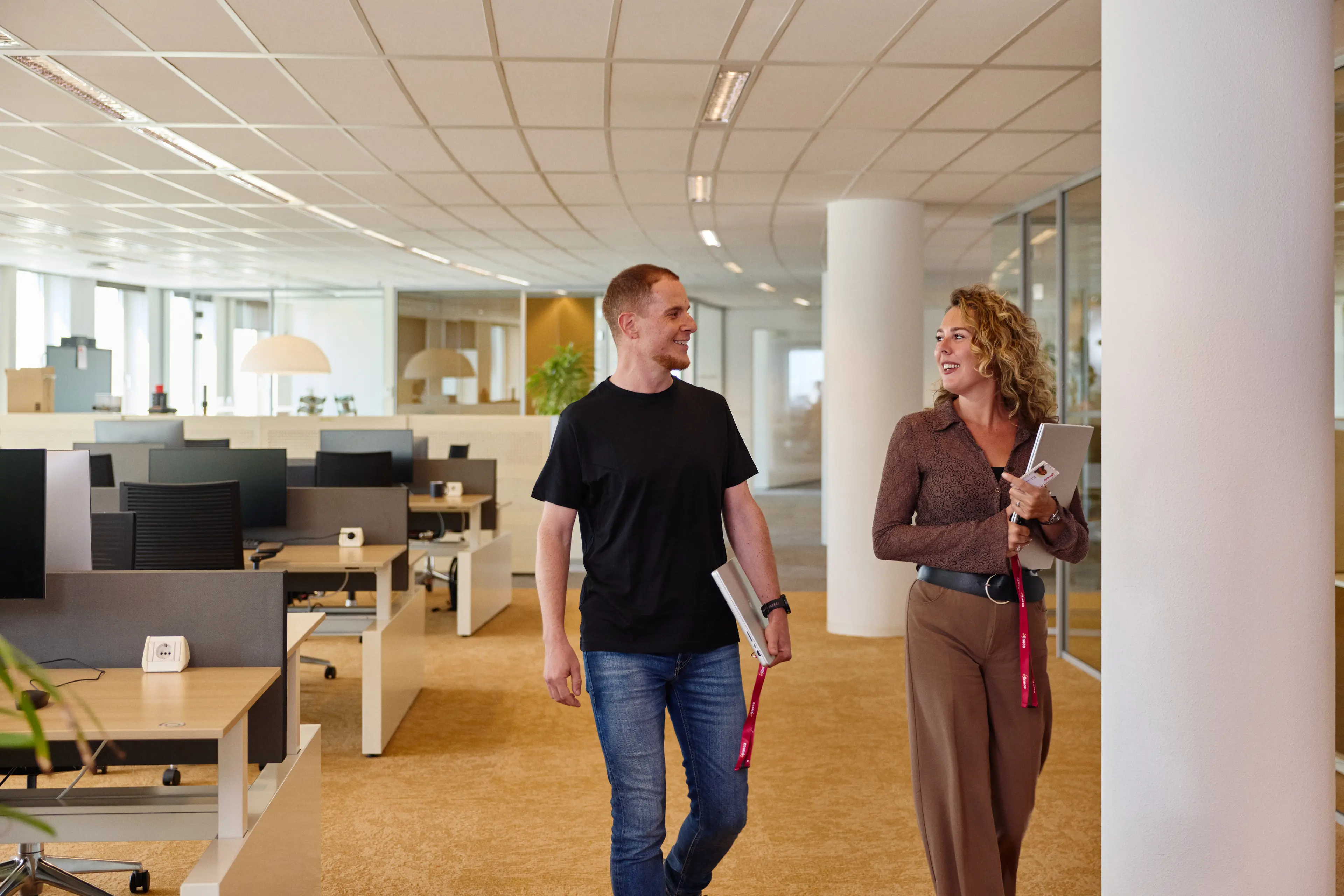 Twee collega's lopen door het kantoor van Eneco eMobility