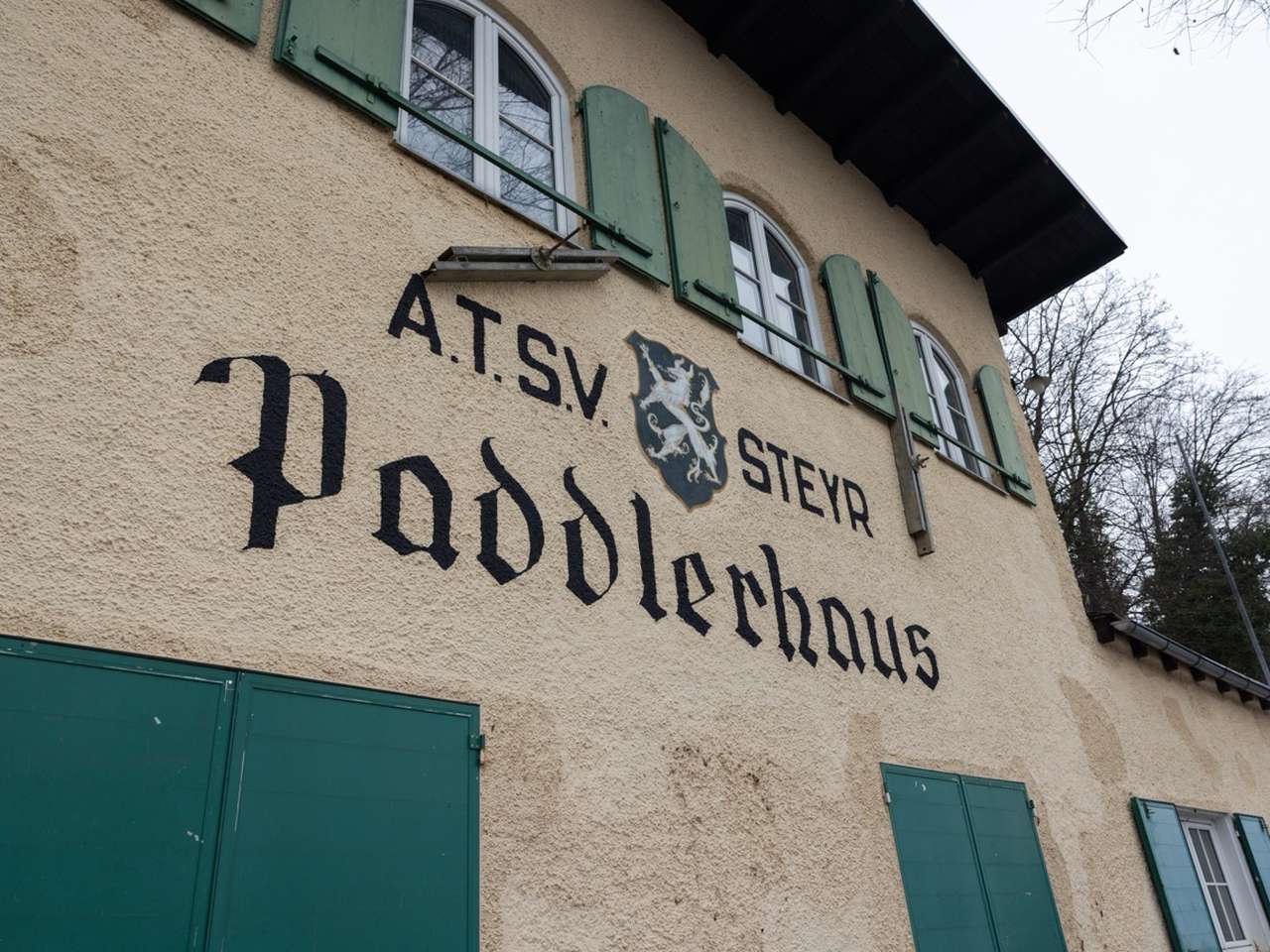 Traditioneller Schriftzug des Paddlerhaus mit originalen Fenstern mit Fensterläden.