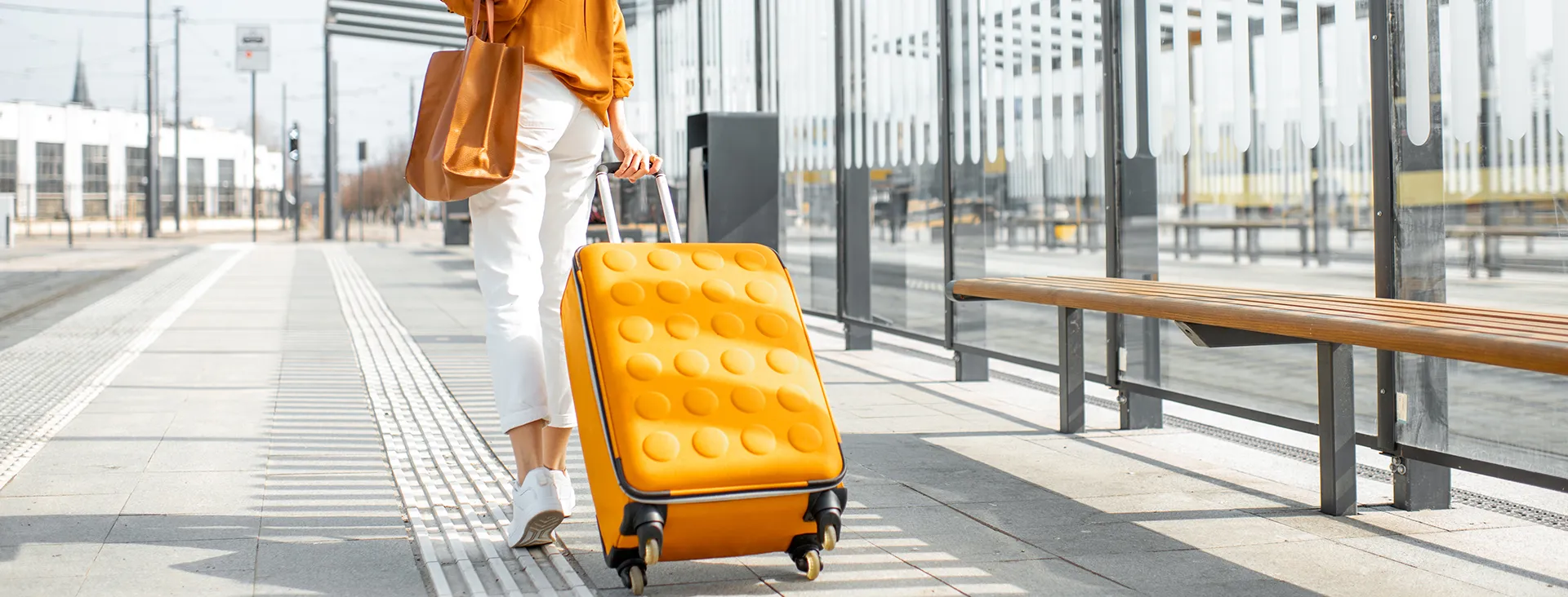 Person at the airport with a bright yellow suitcase