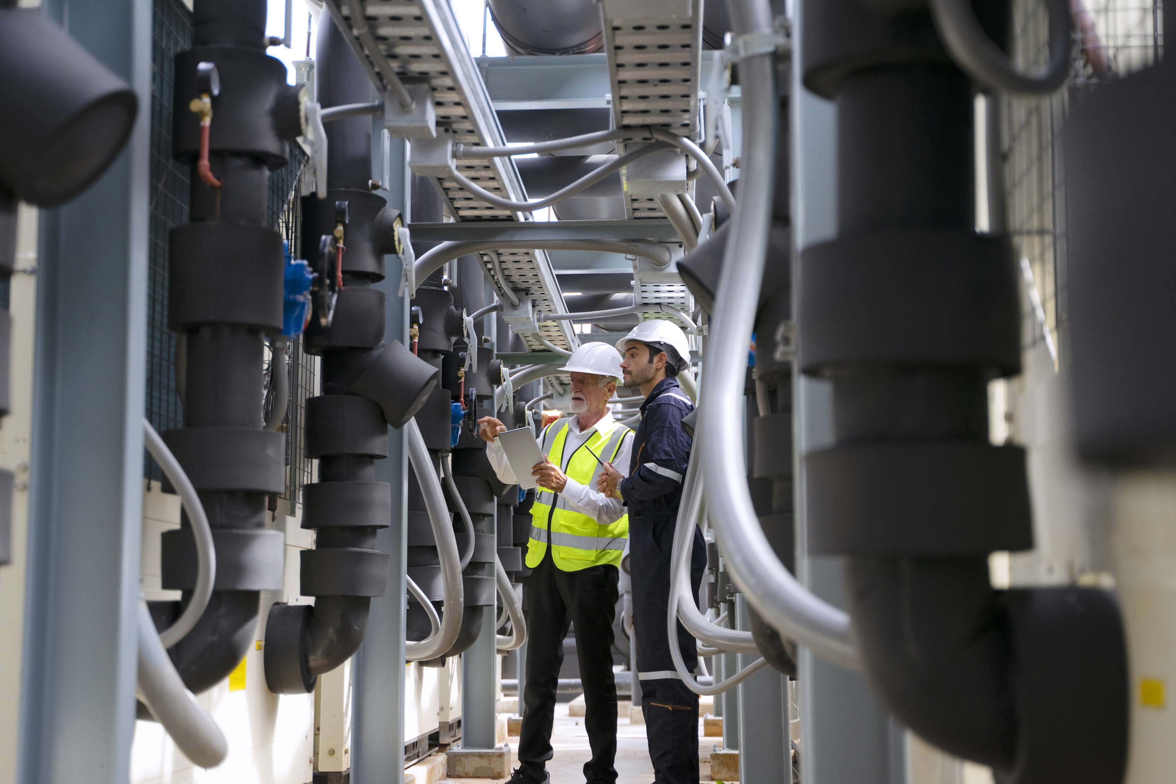 Workers inspecting cooling equipment