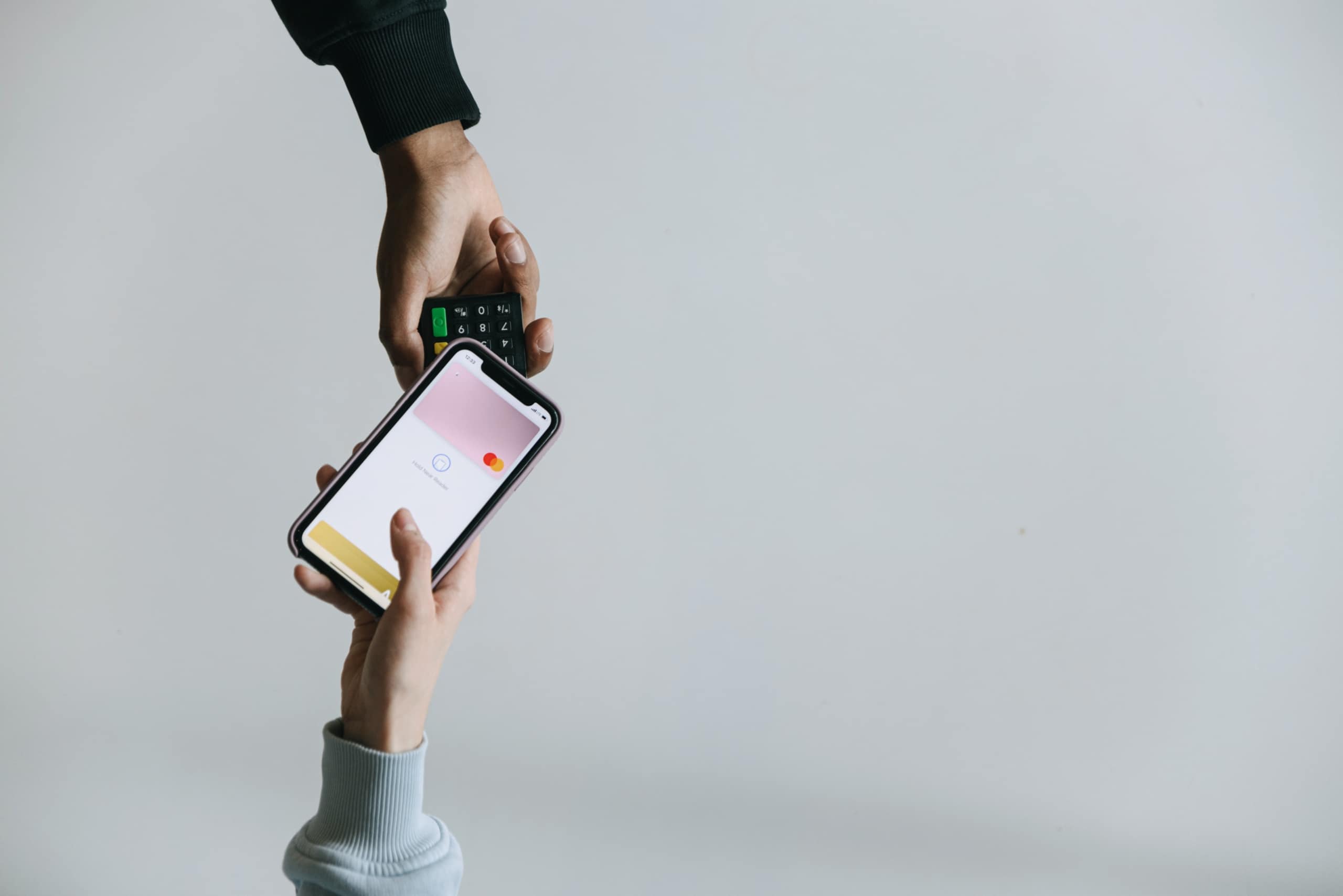 two people passing a phone to each other with a fintech app on the screen