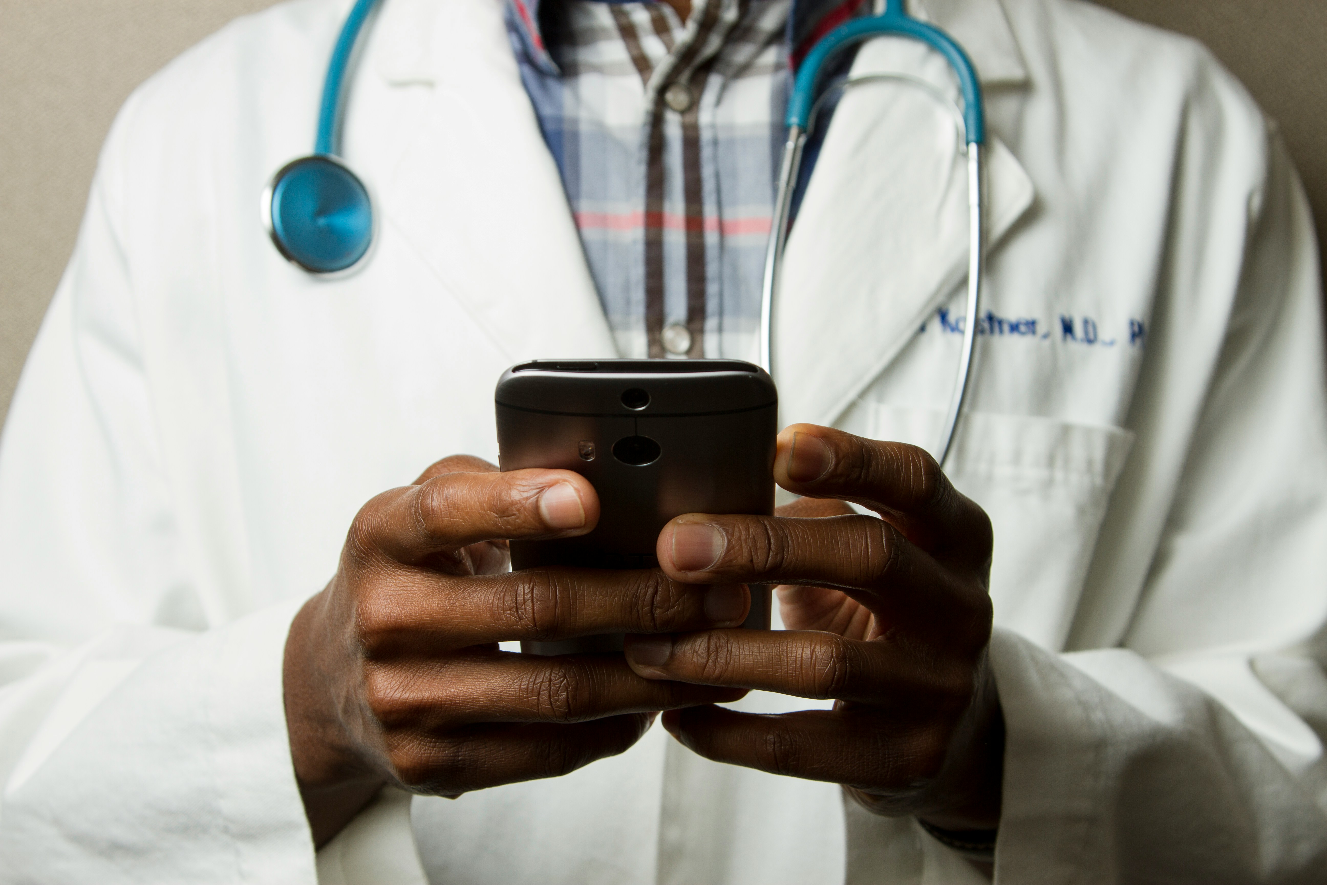 Healthcare professional typing on his phone