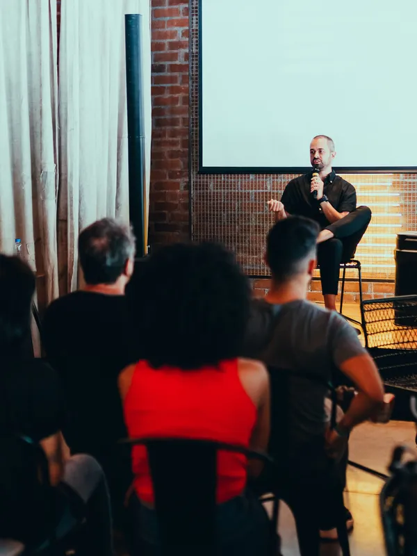 people sitting in a room at a conference with one person speaking at the front of the room