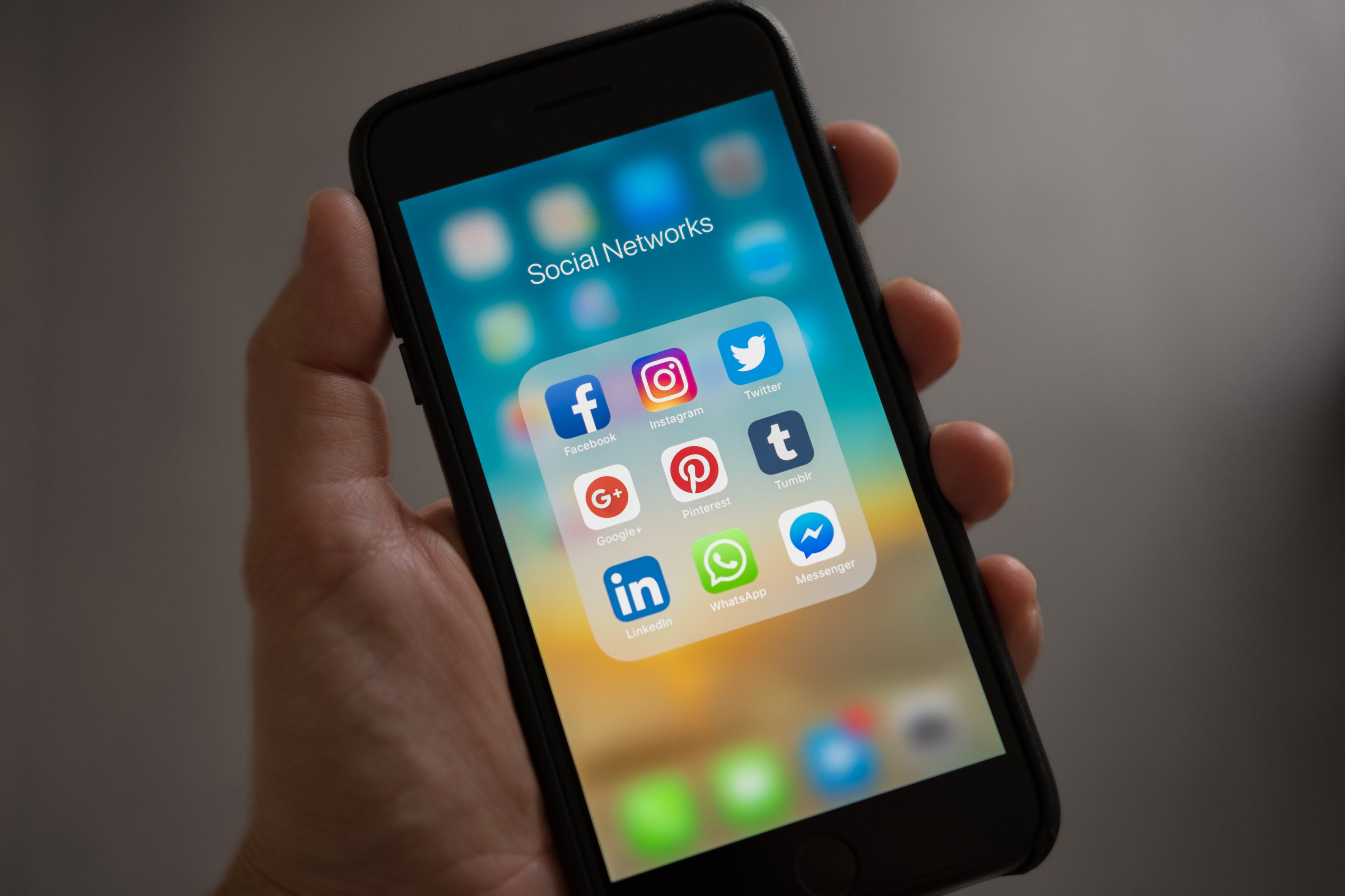 person holding a phone with social media app on the screen