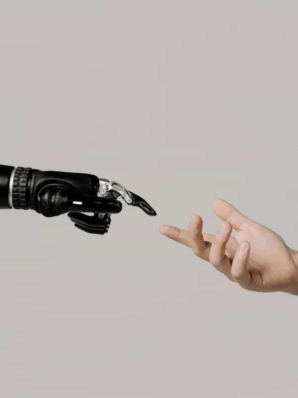A human hand and a robotic hand reaching towards each other, symbolizing the collaboration between humans and AI technology.