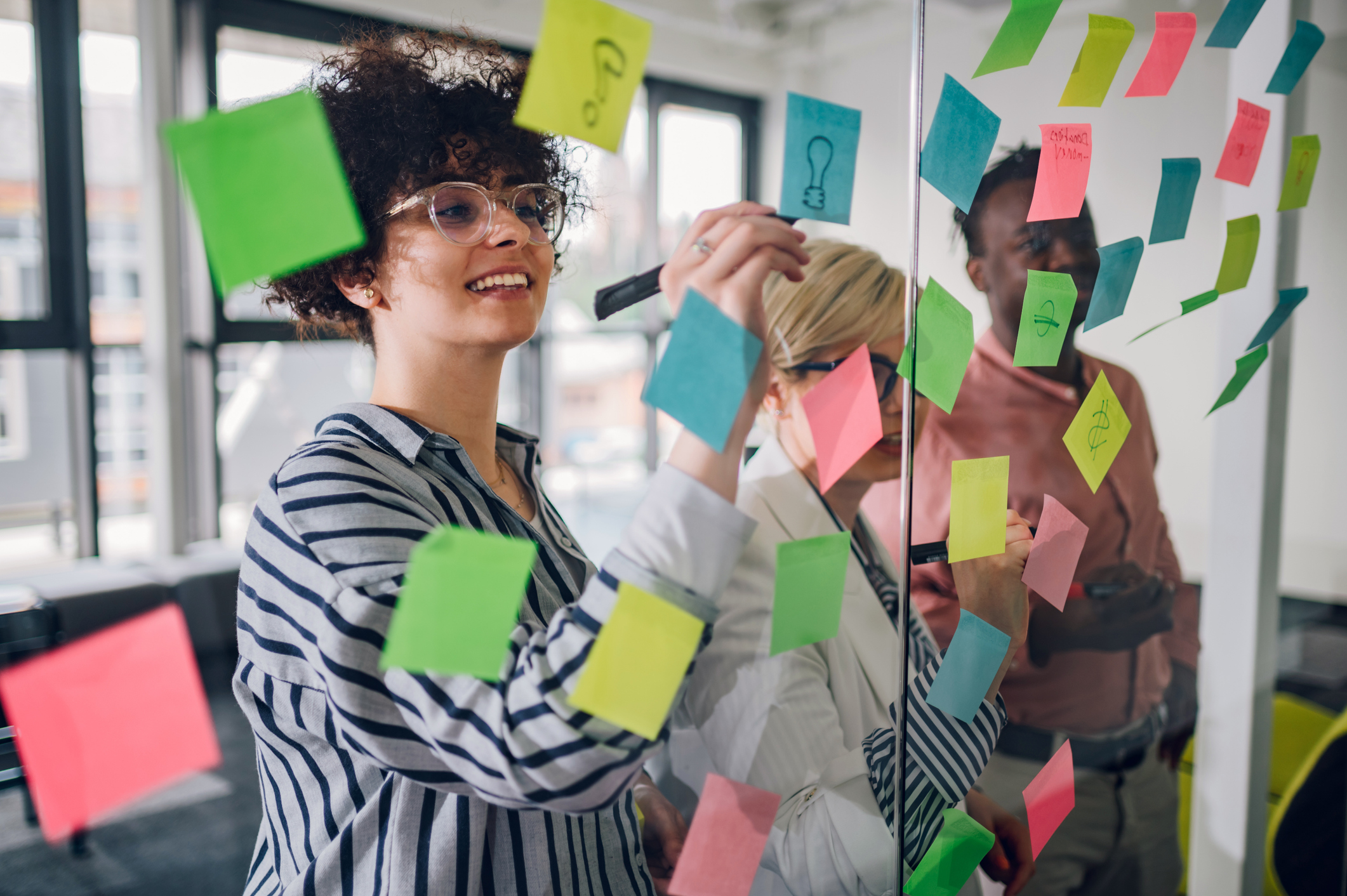 team brainstorm on clear surface with sticky notes