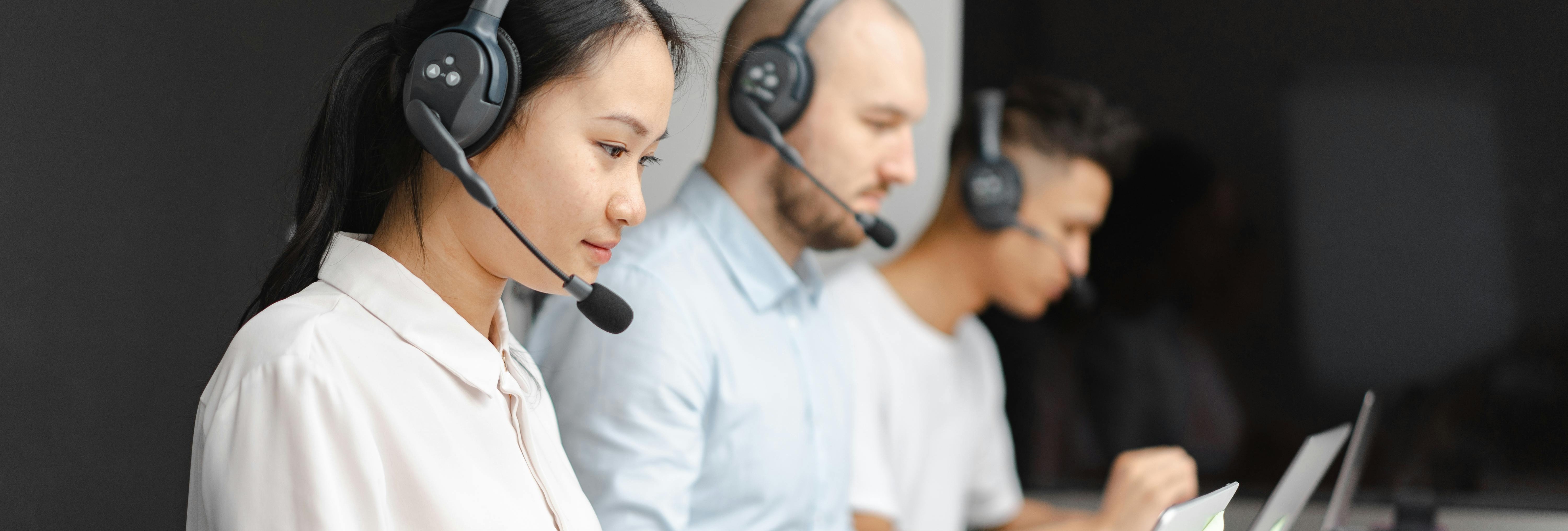Three customer service representatives collecting feedback from users over the phone.
