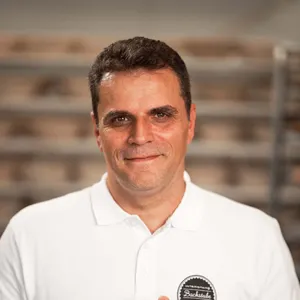 Bäckermeister Alexander Moucka der INTERSPAR-Bäckerei lächelt mit seinem Bäckerliebling in die Kamera