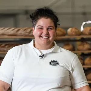 Bäckermeisterin Monika Bernhofer der INTERSPAR-Bäckerei lächelt mit seinem Bäckerliebling in die Kamera