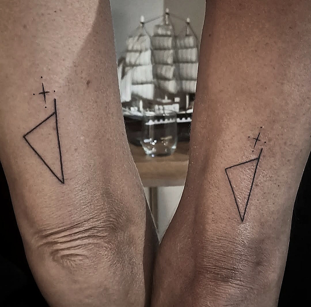 Tatouages de triangles géométriques avec pointillés et petites croix sur les deux avant-bras, réalisés par Steven Chaudesaigues – Graphicaderme Orange