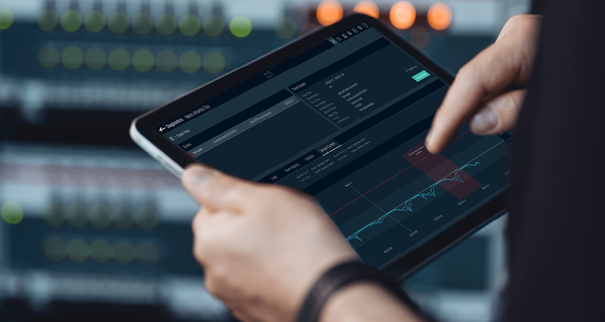 Person holding a tablet displaying a data analytics dashboard with charts and metrics, pointing at a line graph.