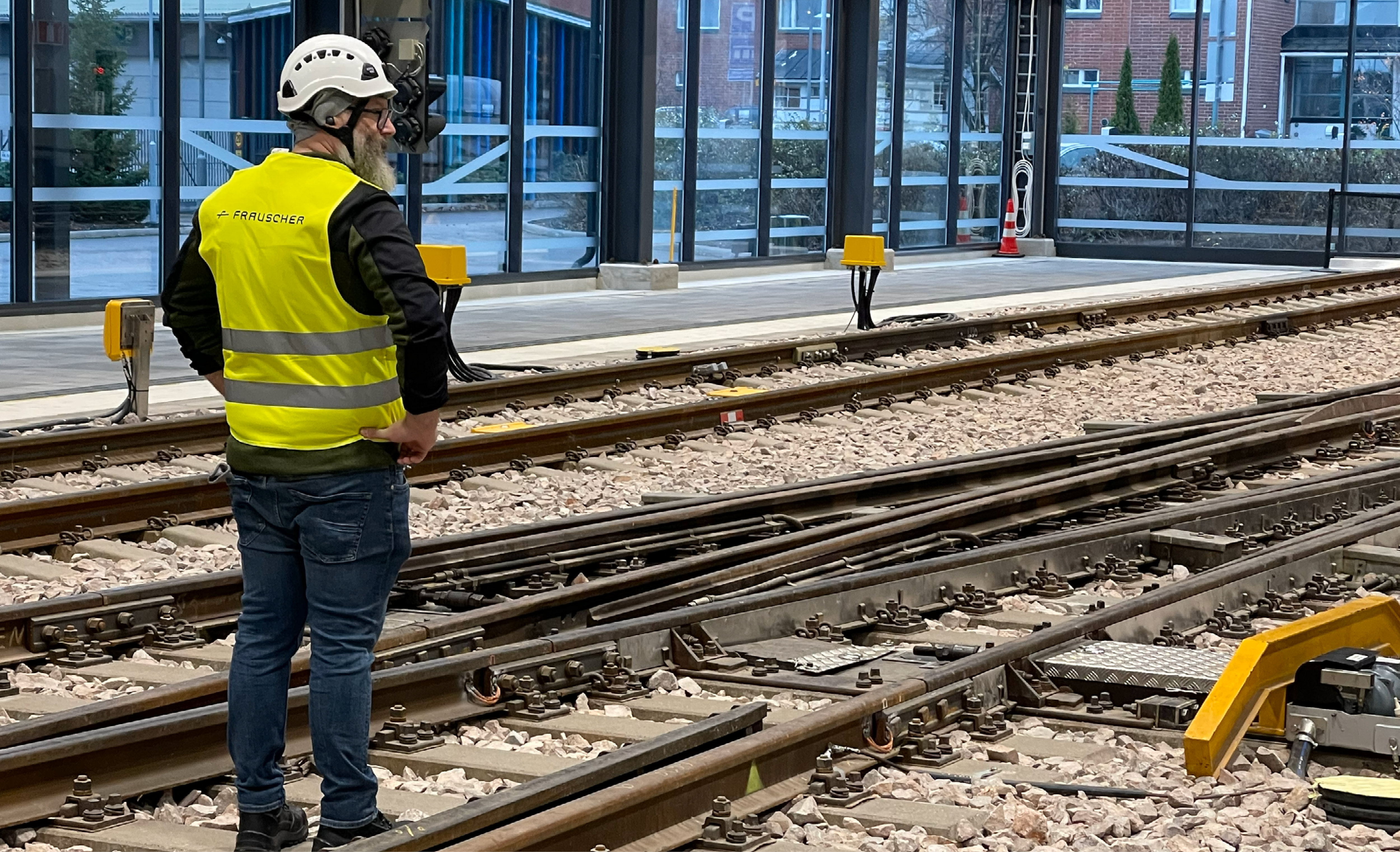Person standing next to tracks and a switch.