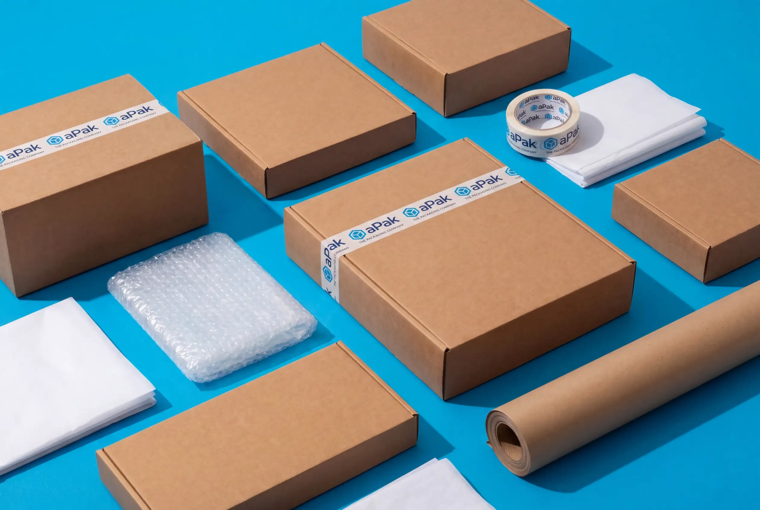 Brown cardboard boxes, packing tape, bubble wrap, and paper, neatly arranged on a blue background.