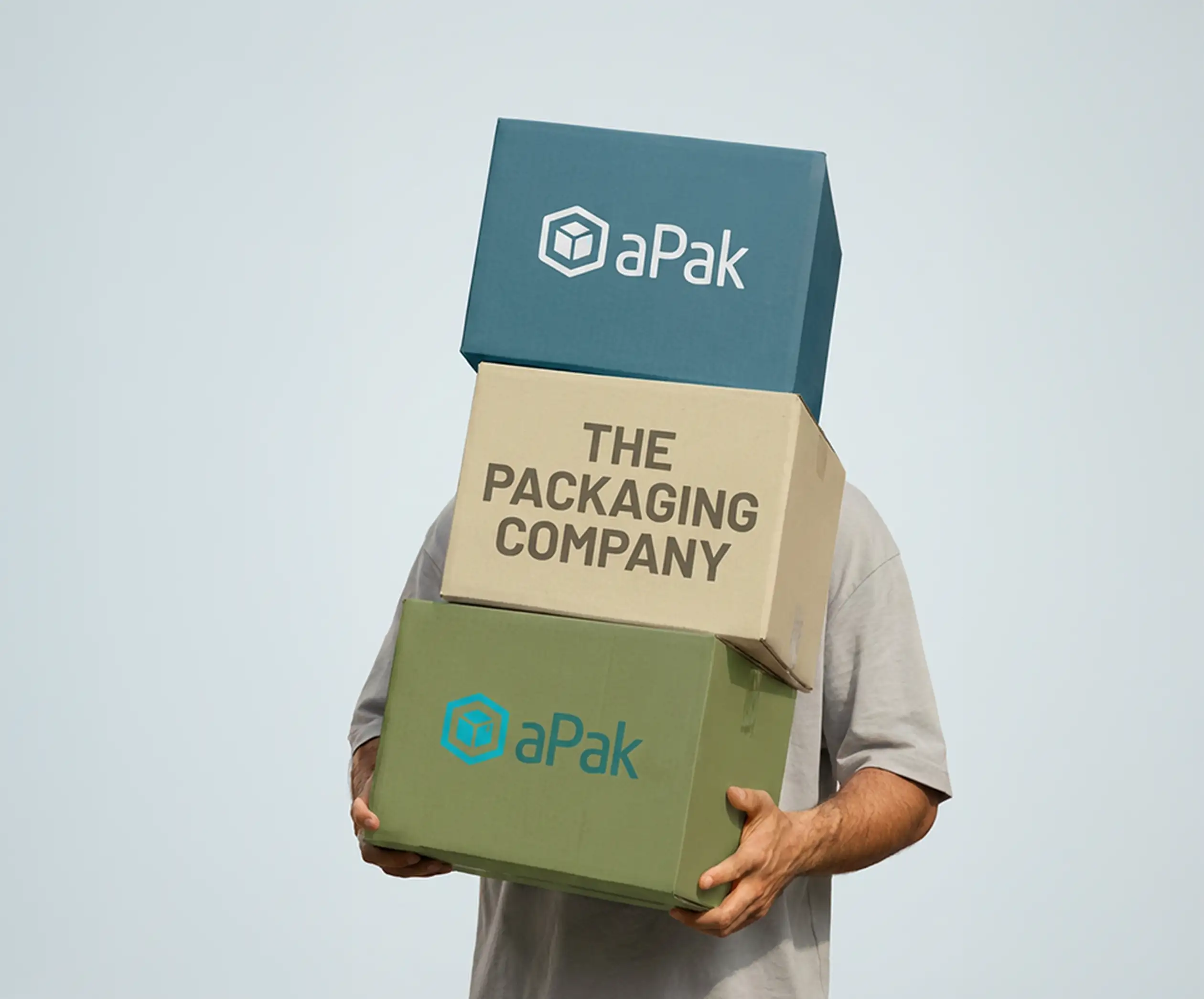 Person holding three stacked boxes, each labeled "aPak" and "The Packaging Company," against a light blue background.