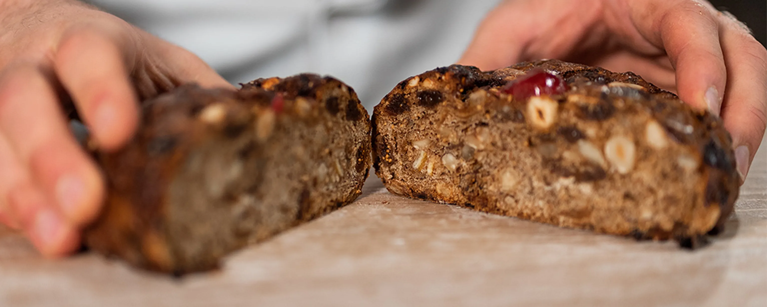 Ein frisch halbiertes Früchtebrot auf einem Brett