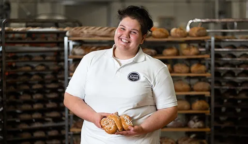 Bäckermeisterin Monika Bernhofer der INTERSPAR-Bäckerei lächelt mit seinem Bäckerliebling in die Kamera