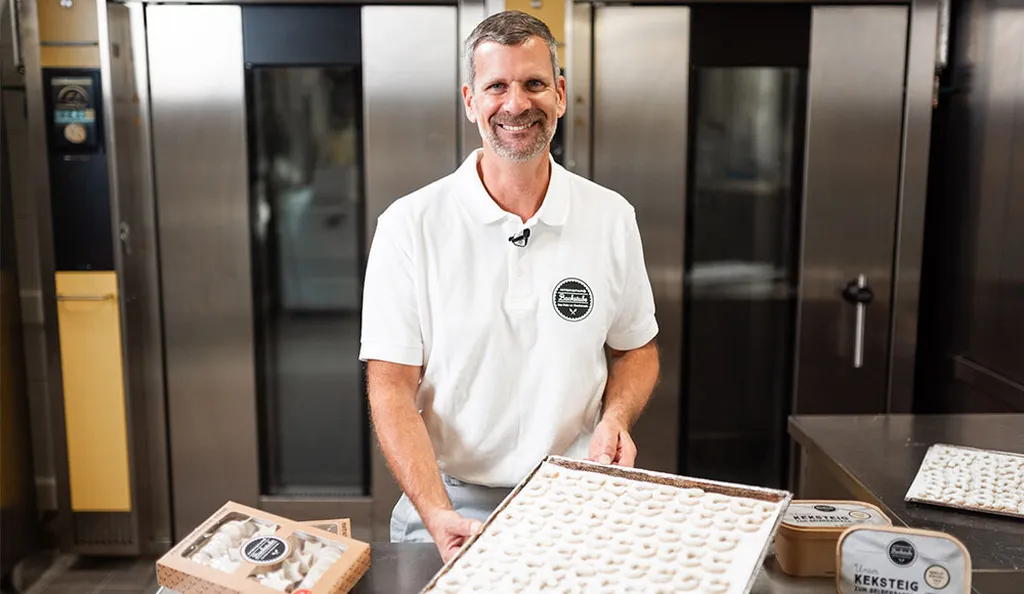 Handwerksbäcker Martin Pürrer der INTERSPAR-Bäckerei lächelt mit seinem Bäckerliebling in die Kamera