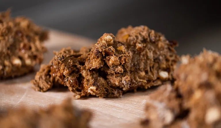 Mehrere Portionen Teig für Früchtebrote liegen auf einem bemehlten Brett