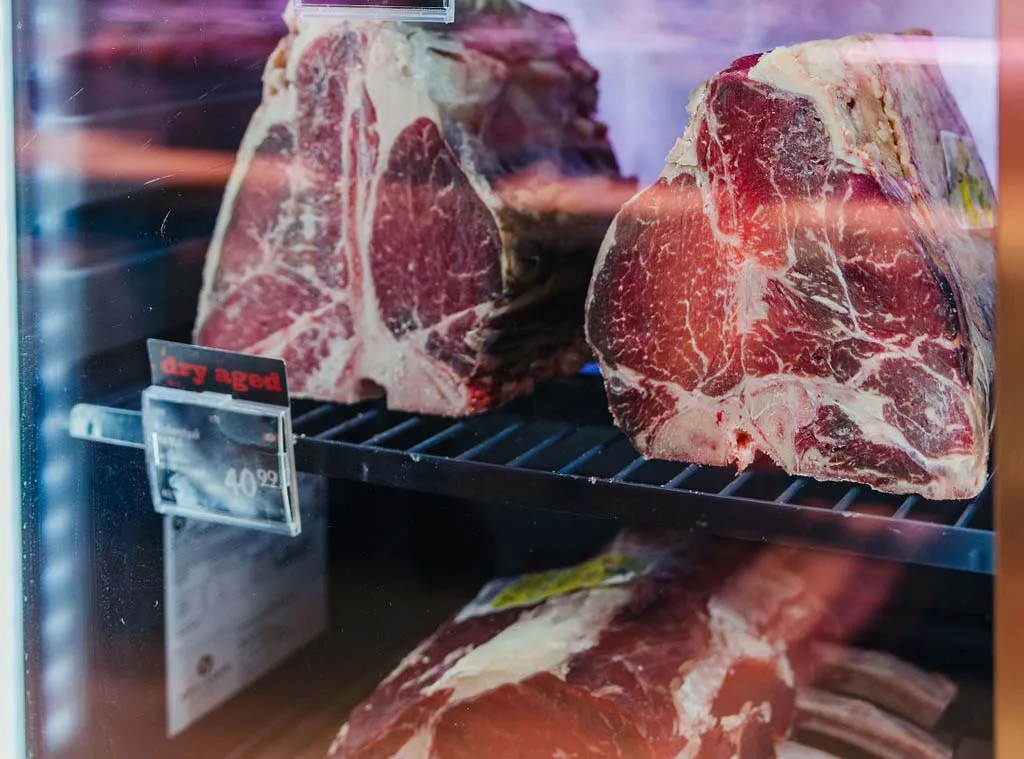 In einer Kühlvitrine ausgestellte, trockengereifte Rindfleischstücke zum Preis von 40,99 pro Stück.