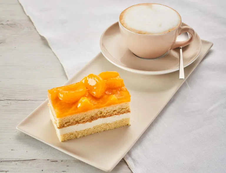 Eine Mandarinenschnitte mit einem Cappuccino aus dem INTERSPAR-Restaurant