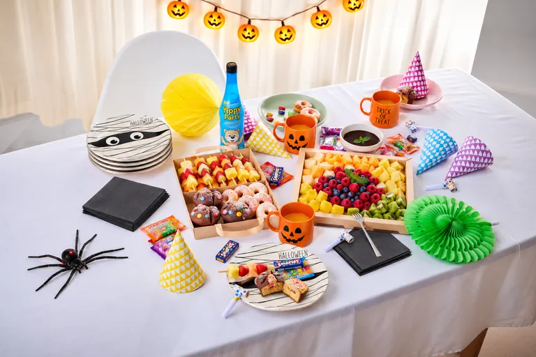 Mehrere verschiedenen Gerichte aus dem INTERSPAR-Partyservice neben verschiedenen Halloween-Dekoartikeln auf einem Tisch